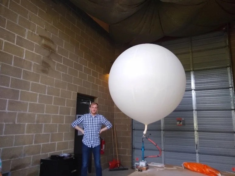 A National Weather Service staff member preparing a weather balloon and radiosonde for launch